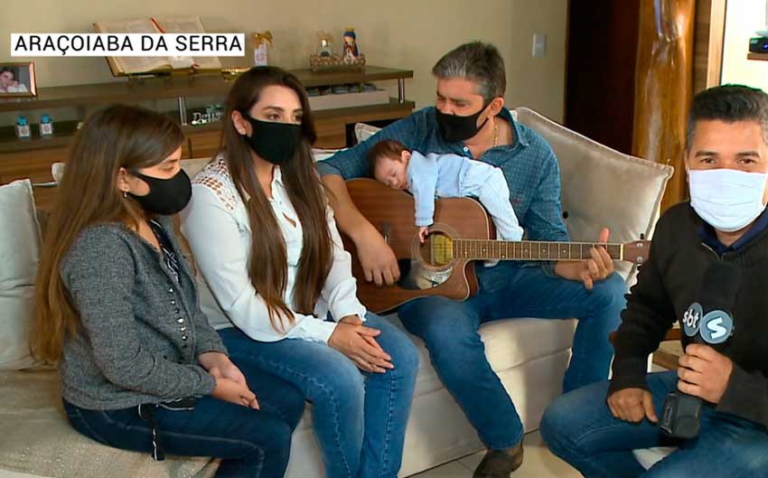 Bebê dorme em violão enquanto pai toca música