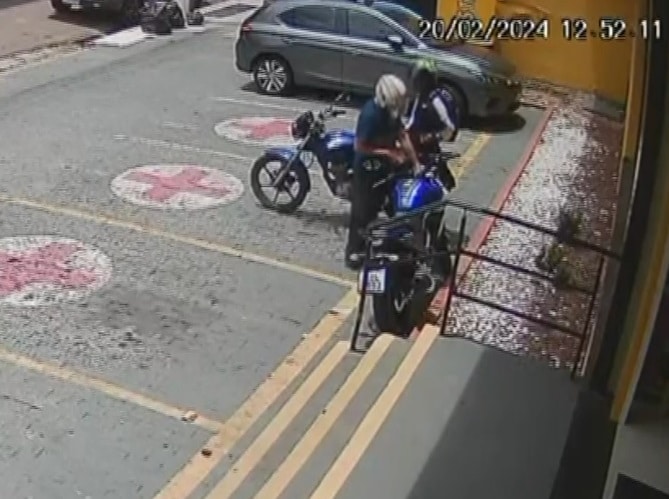 Dupla de criminosos furtando uma moto em um estacionamento
