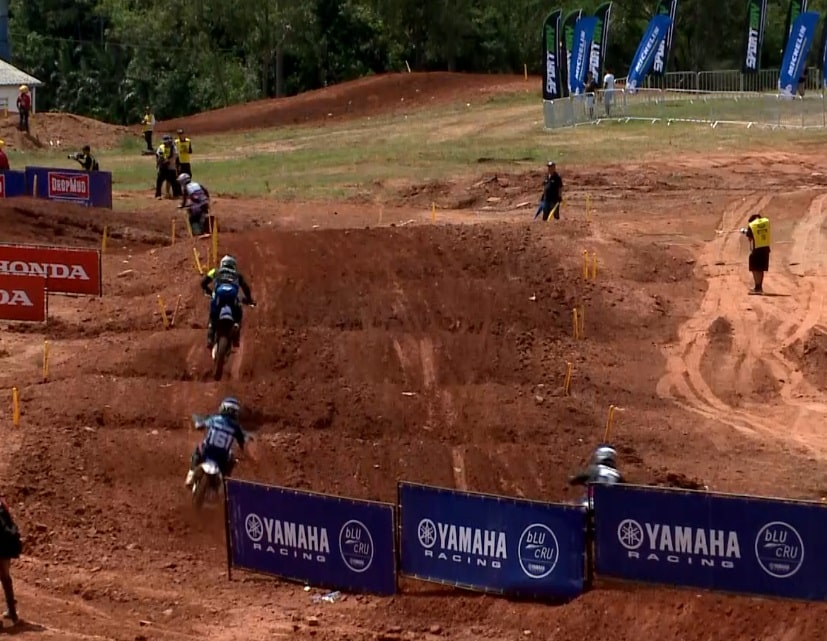 Imagem da pista de motocross com participantes correndo.