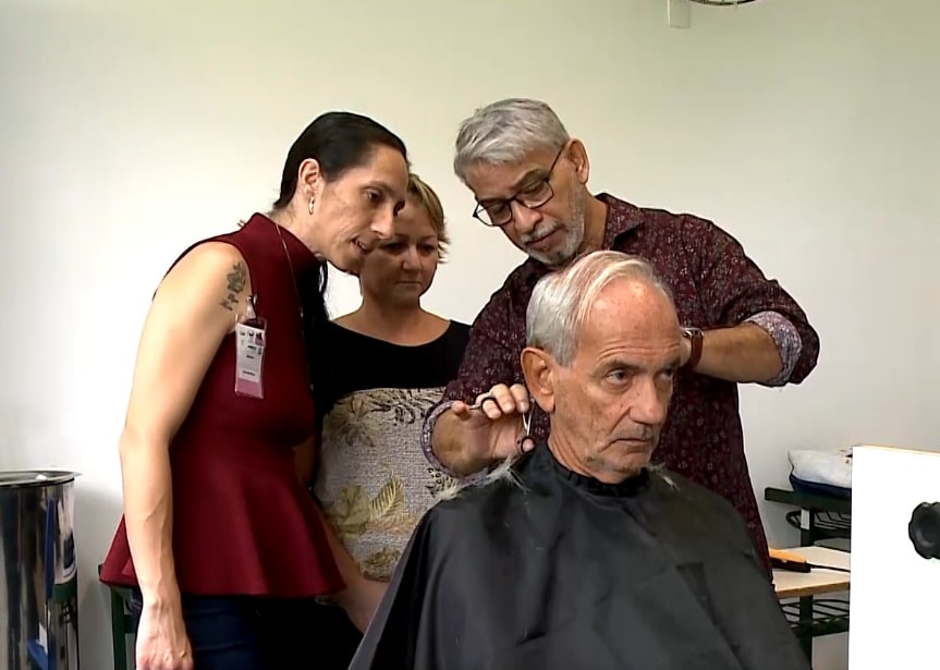 Imagem de professor dando aula de barbearia.