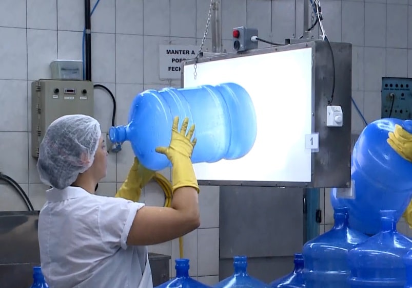 Mulher realizando o processo de tratamento da água.