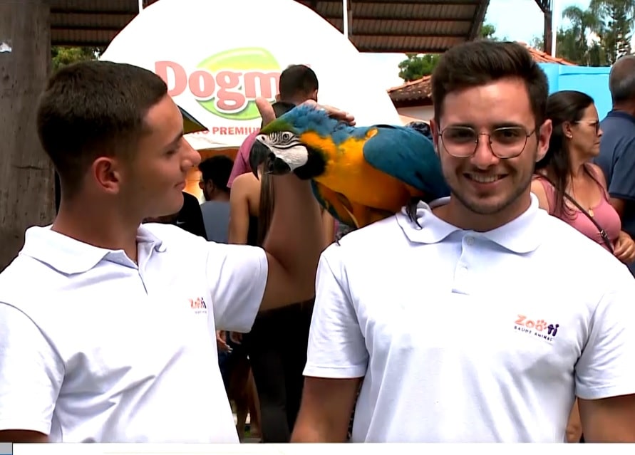 2 homens com uma ave em seu ombro, no evento pet de Araçoiaba da Serra.