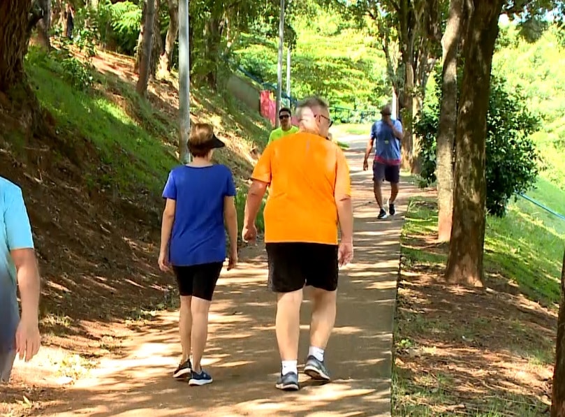 Imagem de casal caminhando em uma praça.