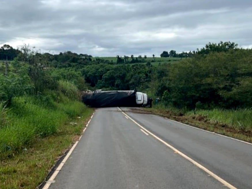 Imagem do caminhão que transportava os pacotes de cigarro, tombado.