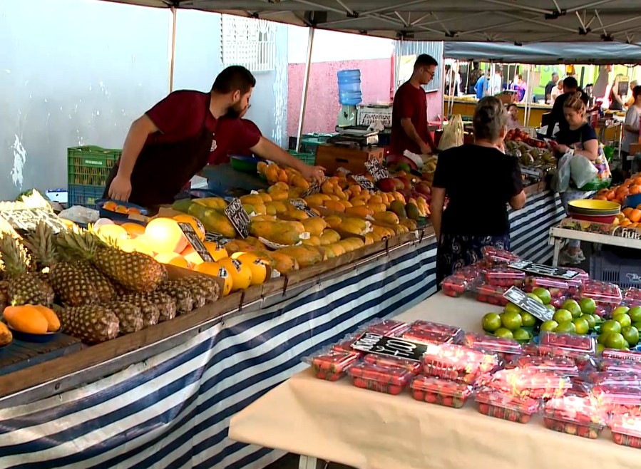 Pessoas e barracas na feira.