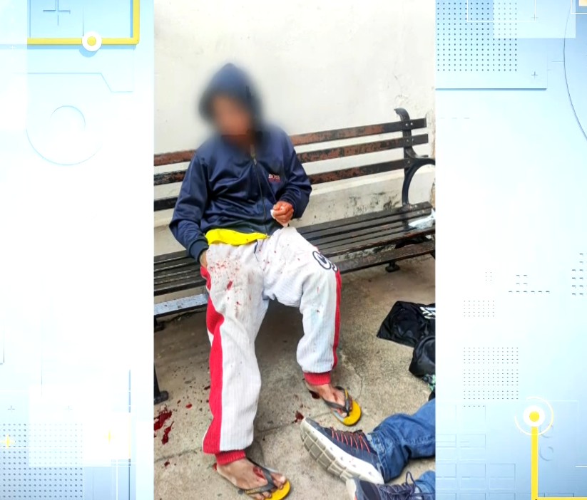 Foto da suspeita sentada no banco, com sangue no ch&atilde;o.