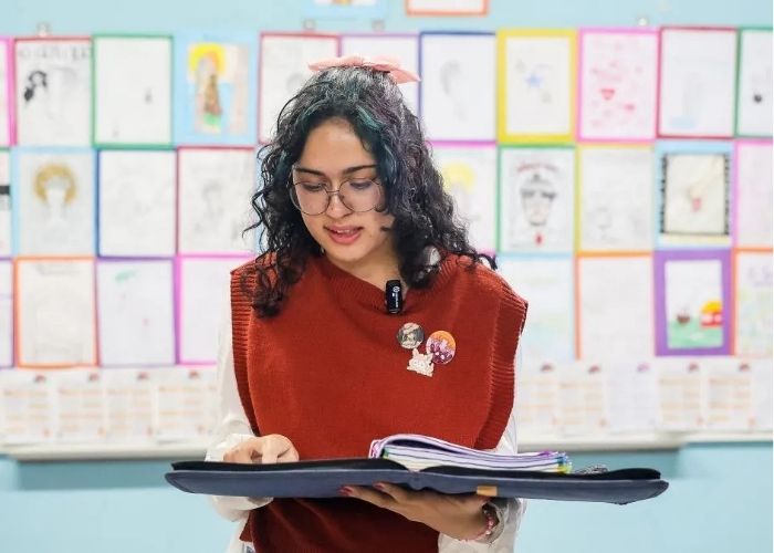 Imagem de uma estudante simluando ler um fichario