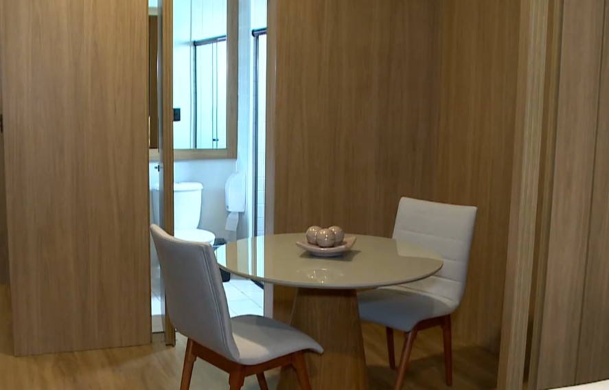 Interior do quarto com uma mesa e duas cadeiras.