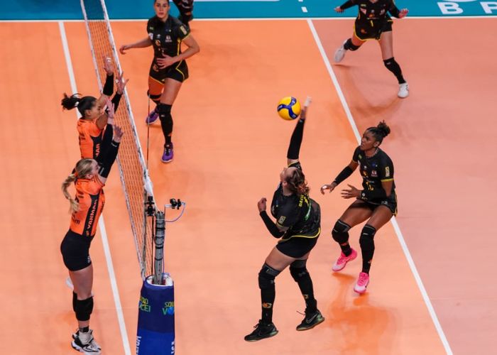 Jogadora do Renasce cortando e Osasco tentando bloquear