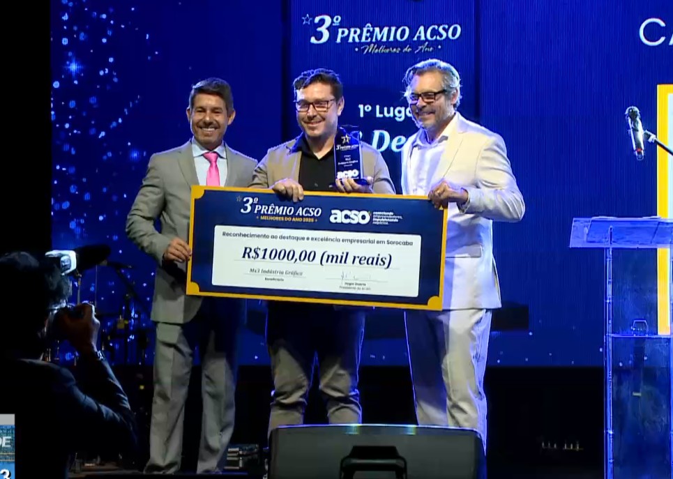 Homens no palco da premia&ccedil;&atilde;o segurando um cheque.