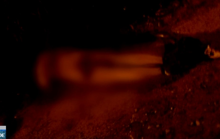 Imagem borrada do corpo jogado na estrada rural.