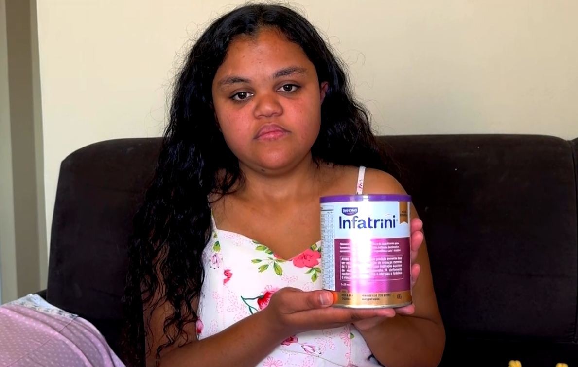 Imagem de m&atilde;e segurando lata de leite em p&oacute;.