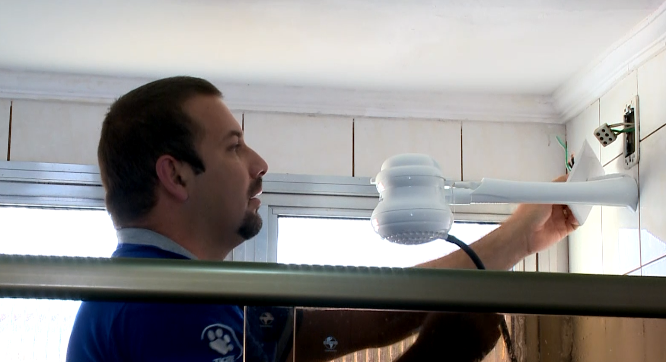 Imagem de homem consertando chuveiro el&eacute;trico.